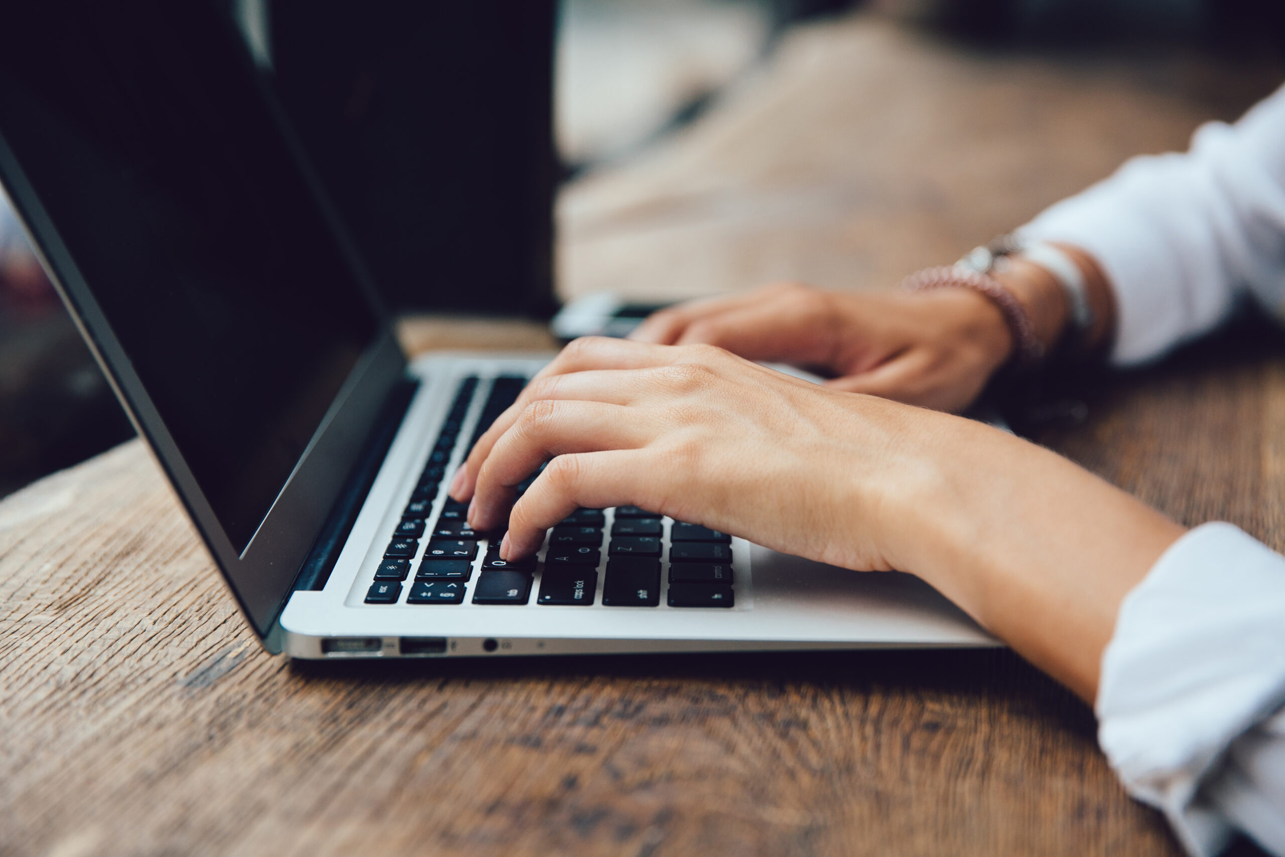 Female hands typing on keyboard of netbook